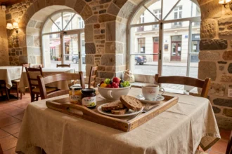 Table de petit-déjeuner dans un hôtel centre-ville de Dijon avec produits du terroir bourguignon, moutarde, pain d'épices et miel local sur nappe en lin