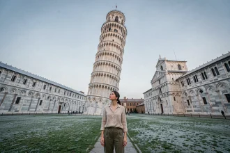 Femme contemplant la Tour de Pise de près en matinée calme sans foule sur la Piazza dei Miracoli